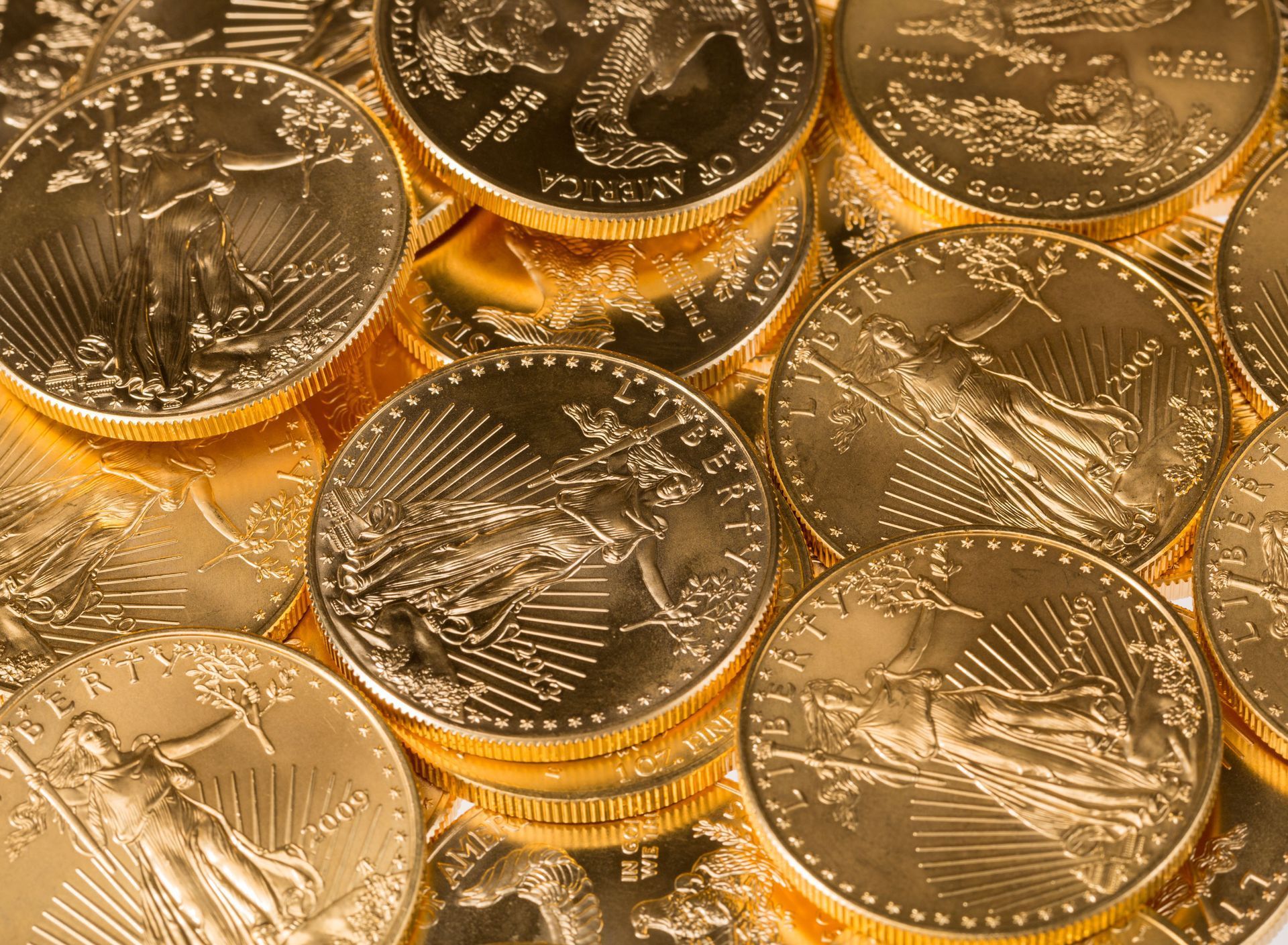 Pile of gold coins with intricate designs, glistening in the light.