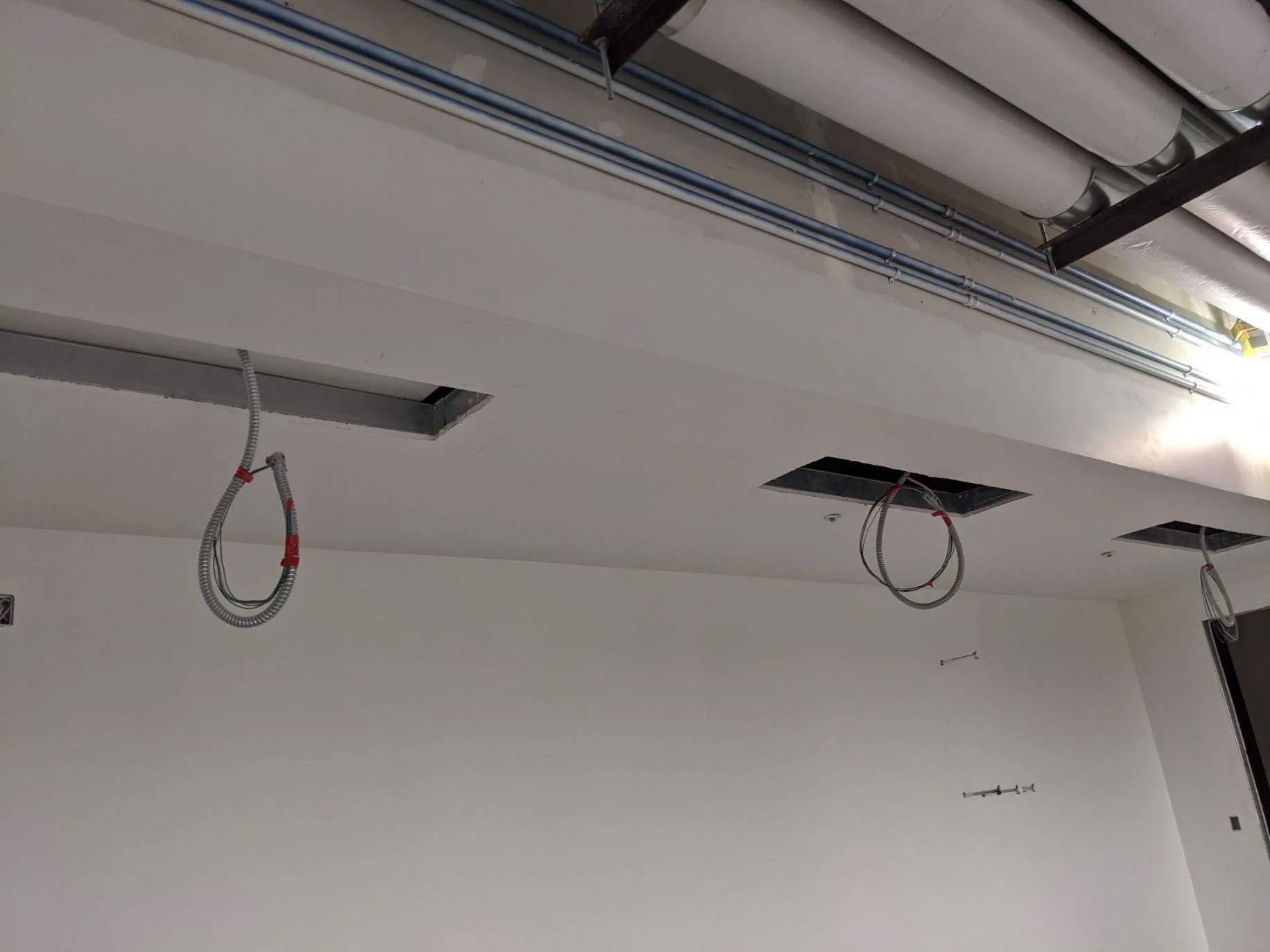 White ceiling with cutouts for lights, wires hanging.