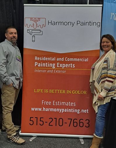 Two people stand by a sign for