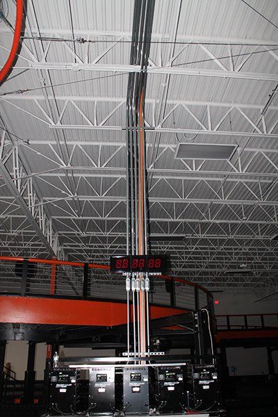 A digital clock is hanging from the ceiling of a building