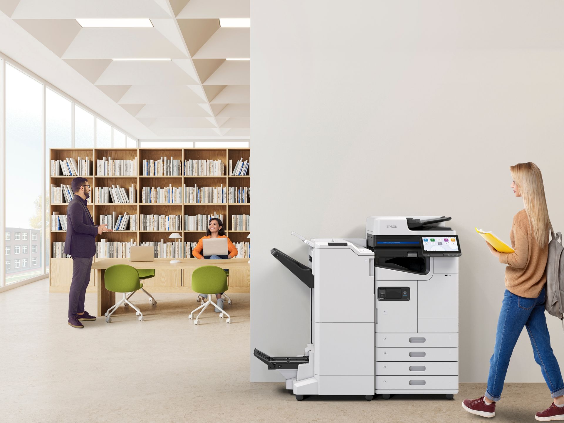 A woman is walking in front of a printer in a library.