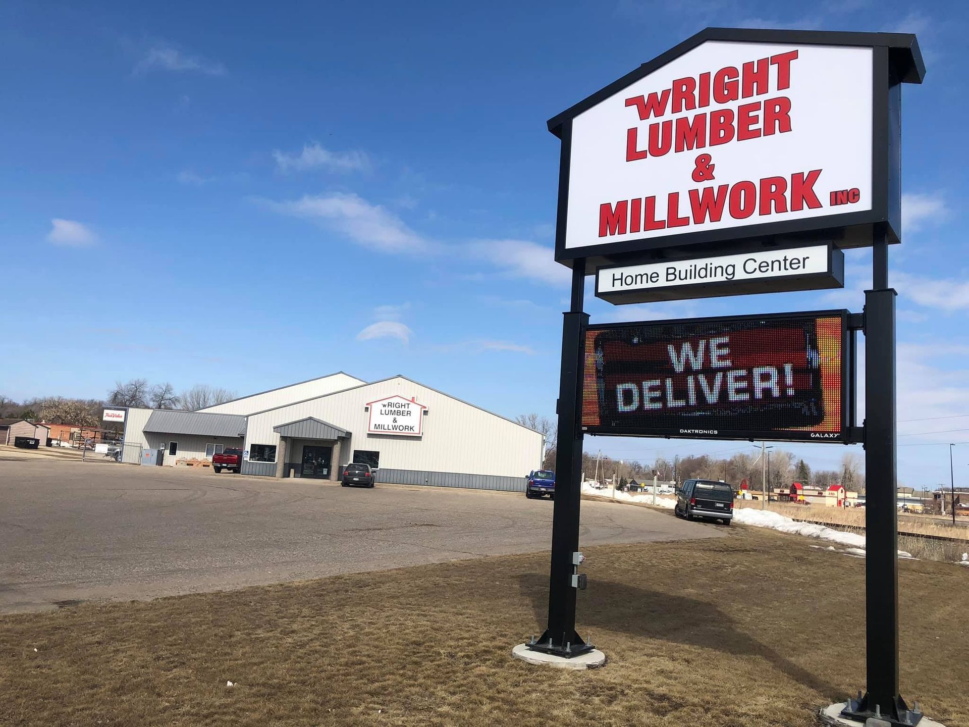 Wright Lumber Millwork sign beside a white lumber yard building under a blue sky