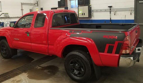 A red pickup truck is parked in a garage.