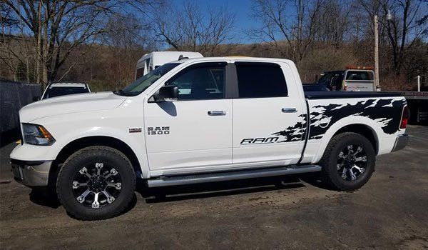 A white dodge ram truck is parked in a parking lot.