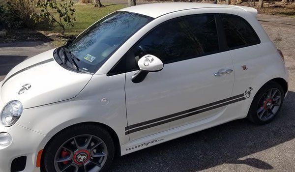 A white car is parked on the side of the road.