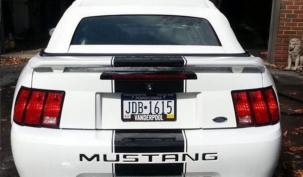 A white mustang with a license plate that says jdb-1615