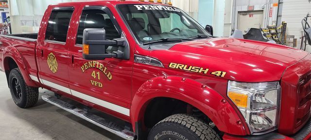 A red pickup truck is parked in a garage.