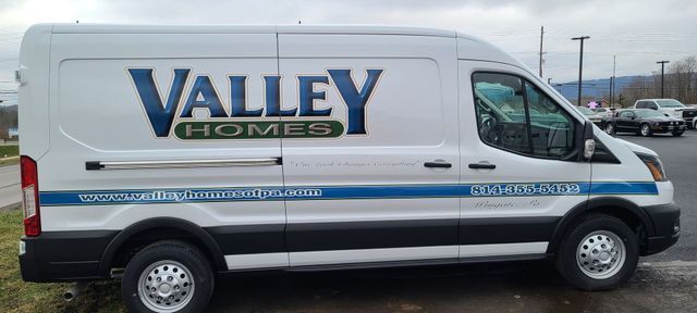 A white van with valley homes written on the side is parked in a parking lot.