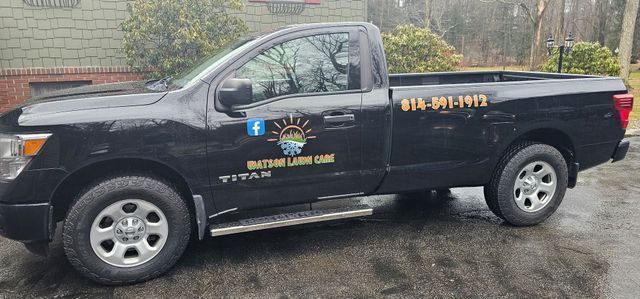 A black truck is parked in front of a house.