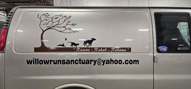 A van with a picture of a tree and dogs on it