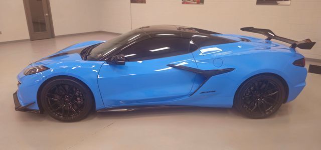 A blue sports car is parked in a garage.