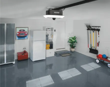 Garage interior with a car lift, cabinets, fridge, tools, and a red wagon.