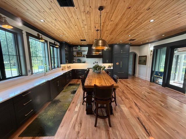 A kitchen with a wooden table and chairs and a wooden ceiling