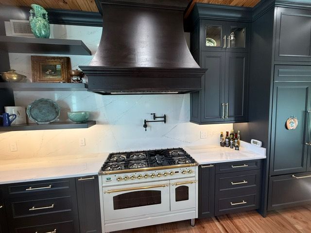 A kitchen with black cabinets and a white stove top oven