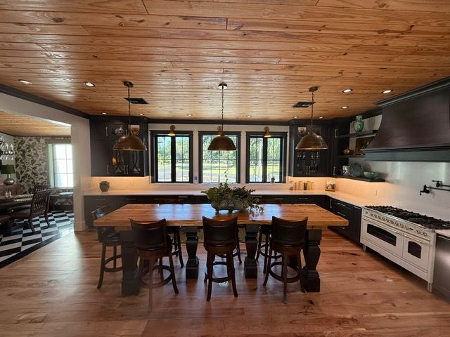 A kitchen with a large wooden table and chairs