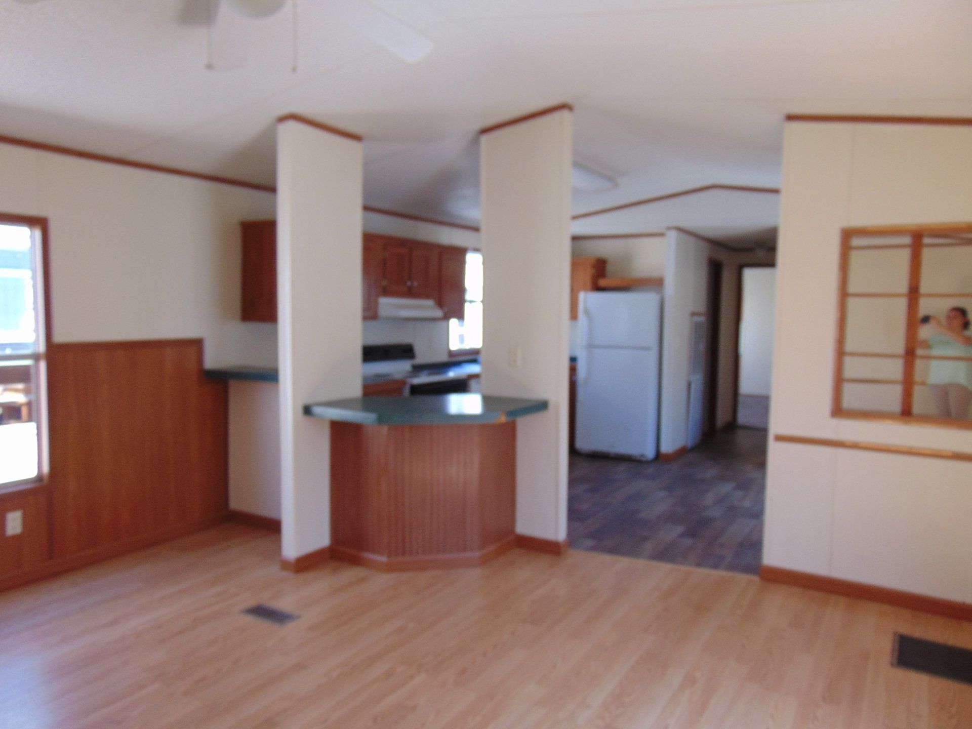 An empty house with a kitchen and a refrigerator