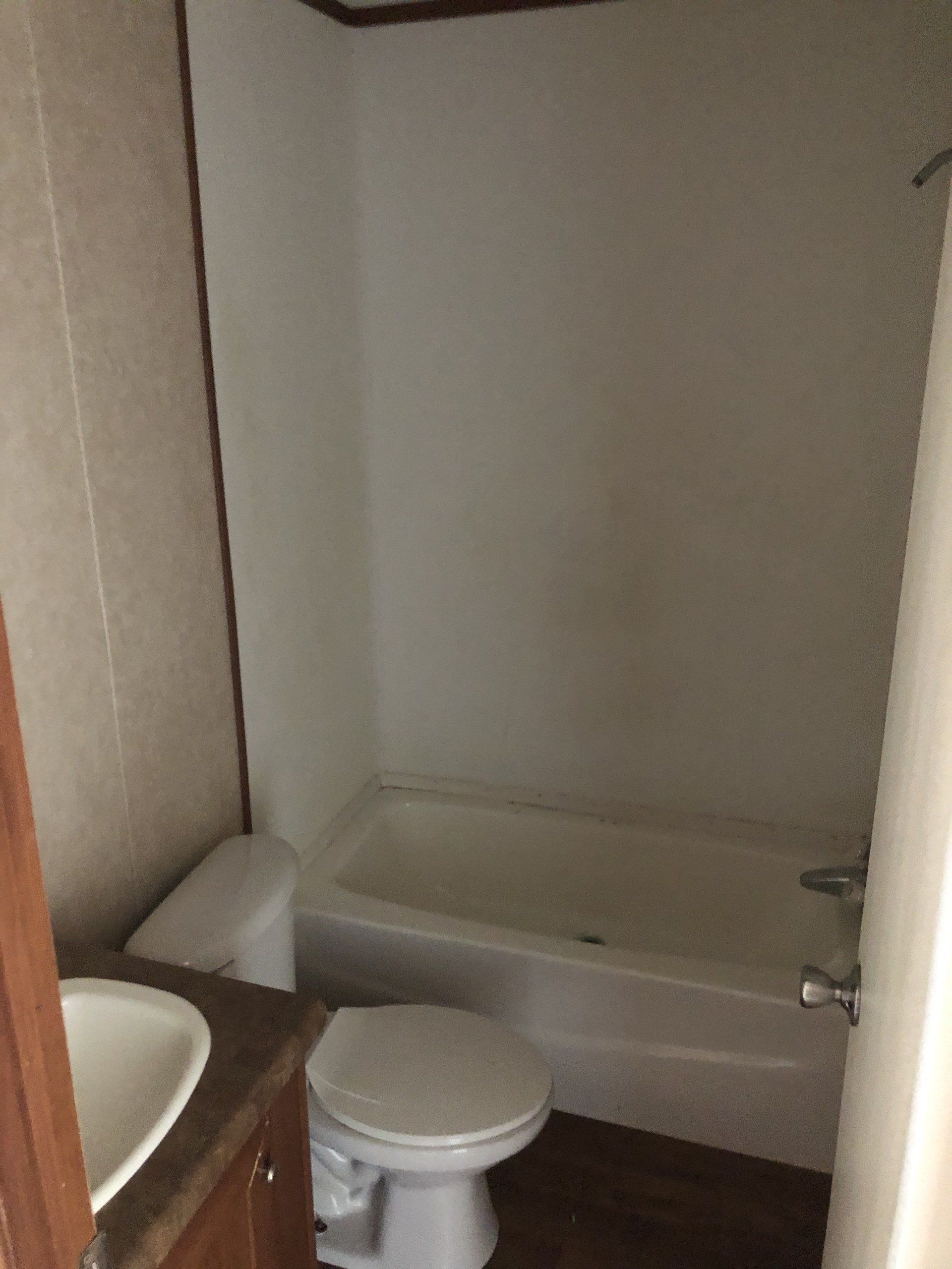 A bathroom with a toilet, sink and bathtub