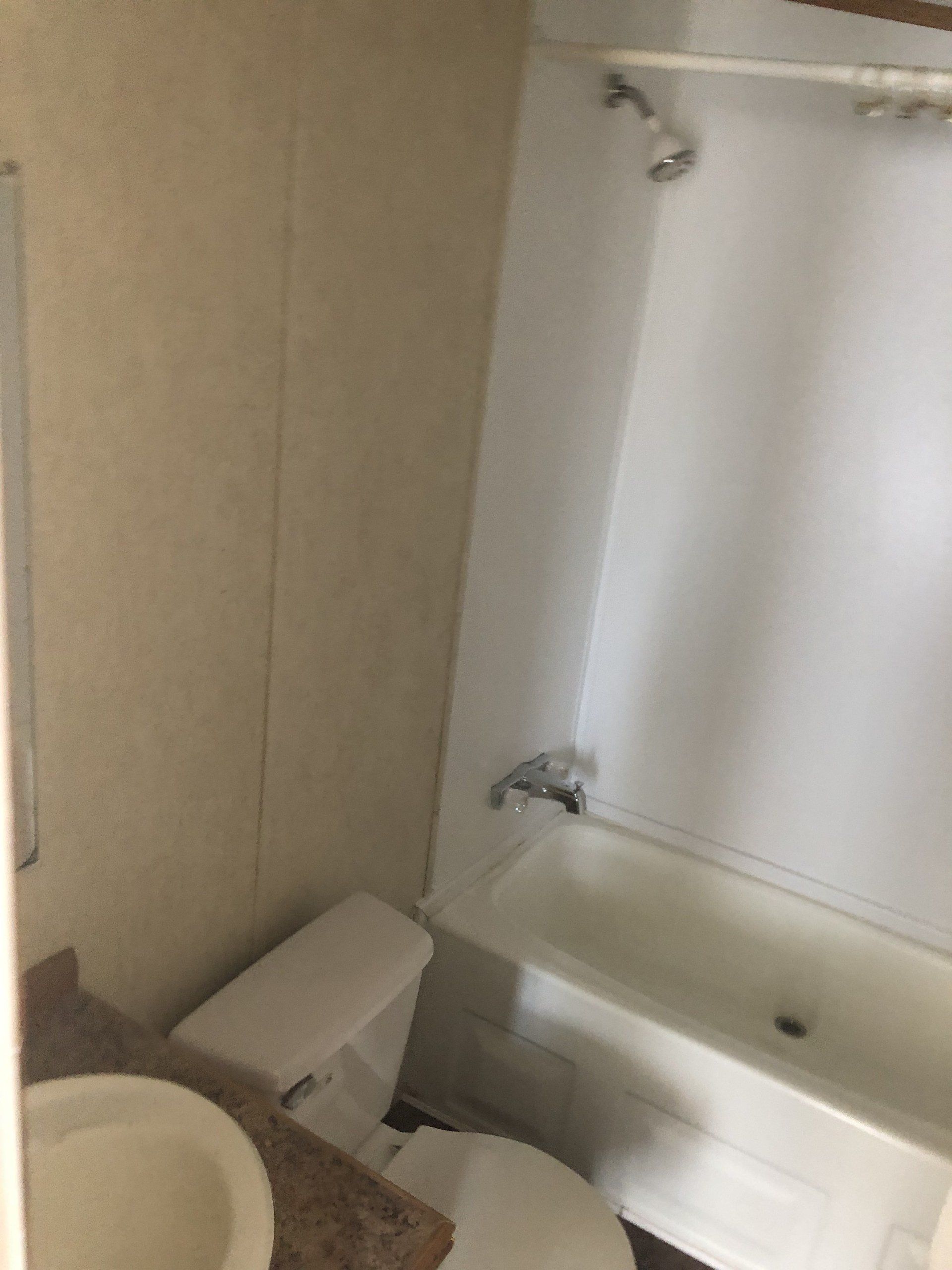 A bathroom with a toilet, sink and bathtub