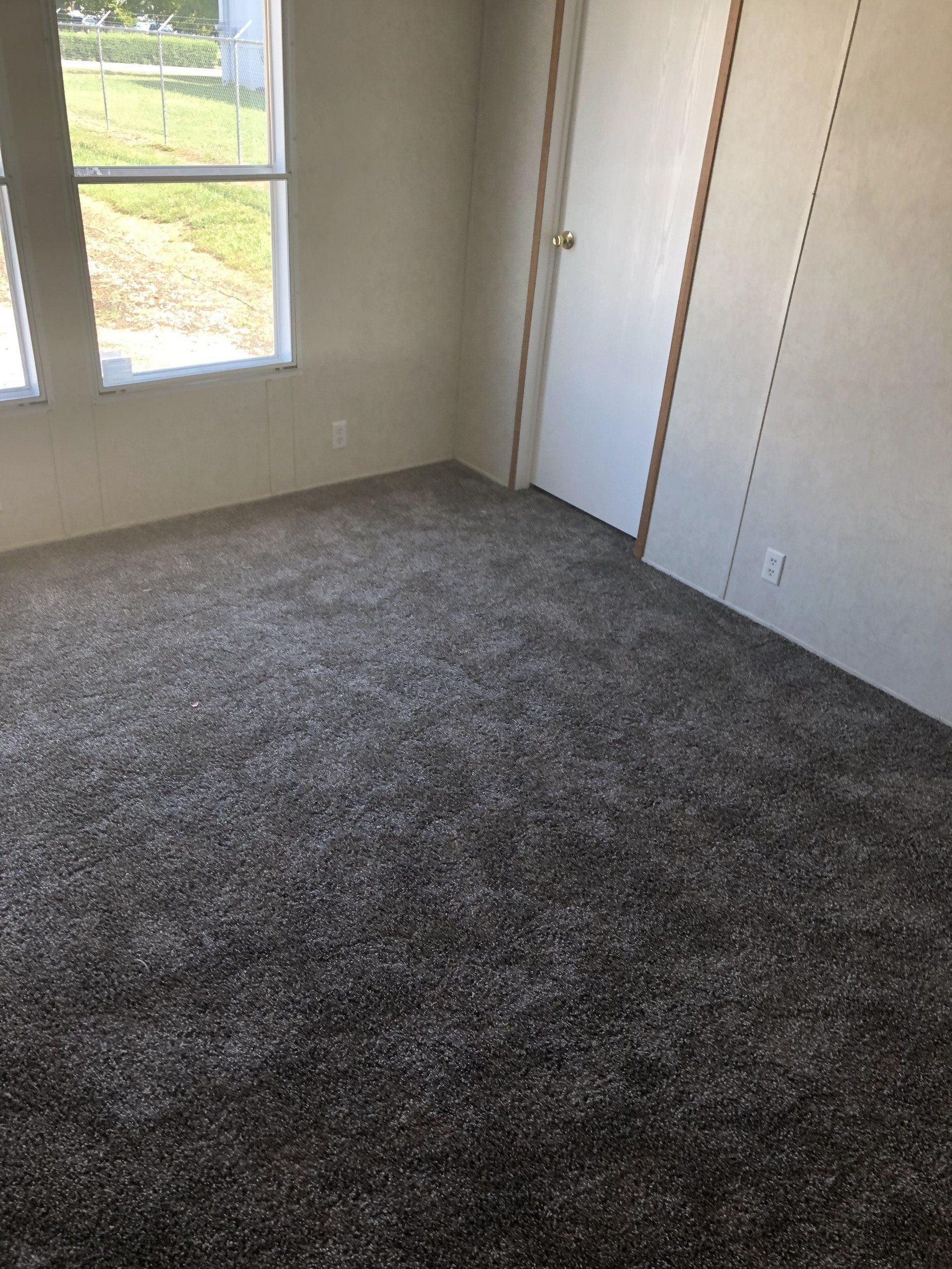 A bedroom with a carpeted floor and a window
