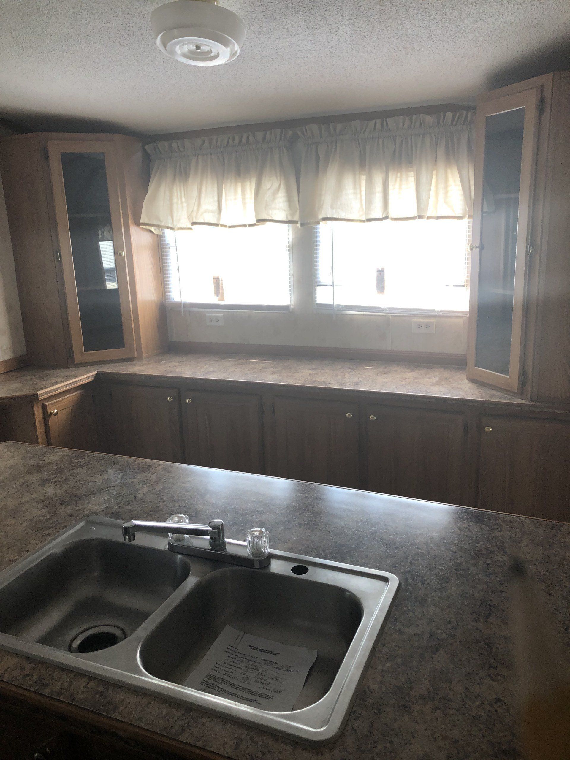 An empty kitchen with a sink and a window
