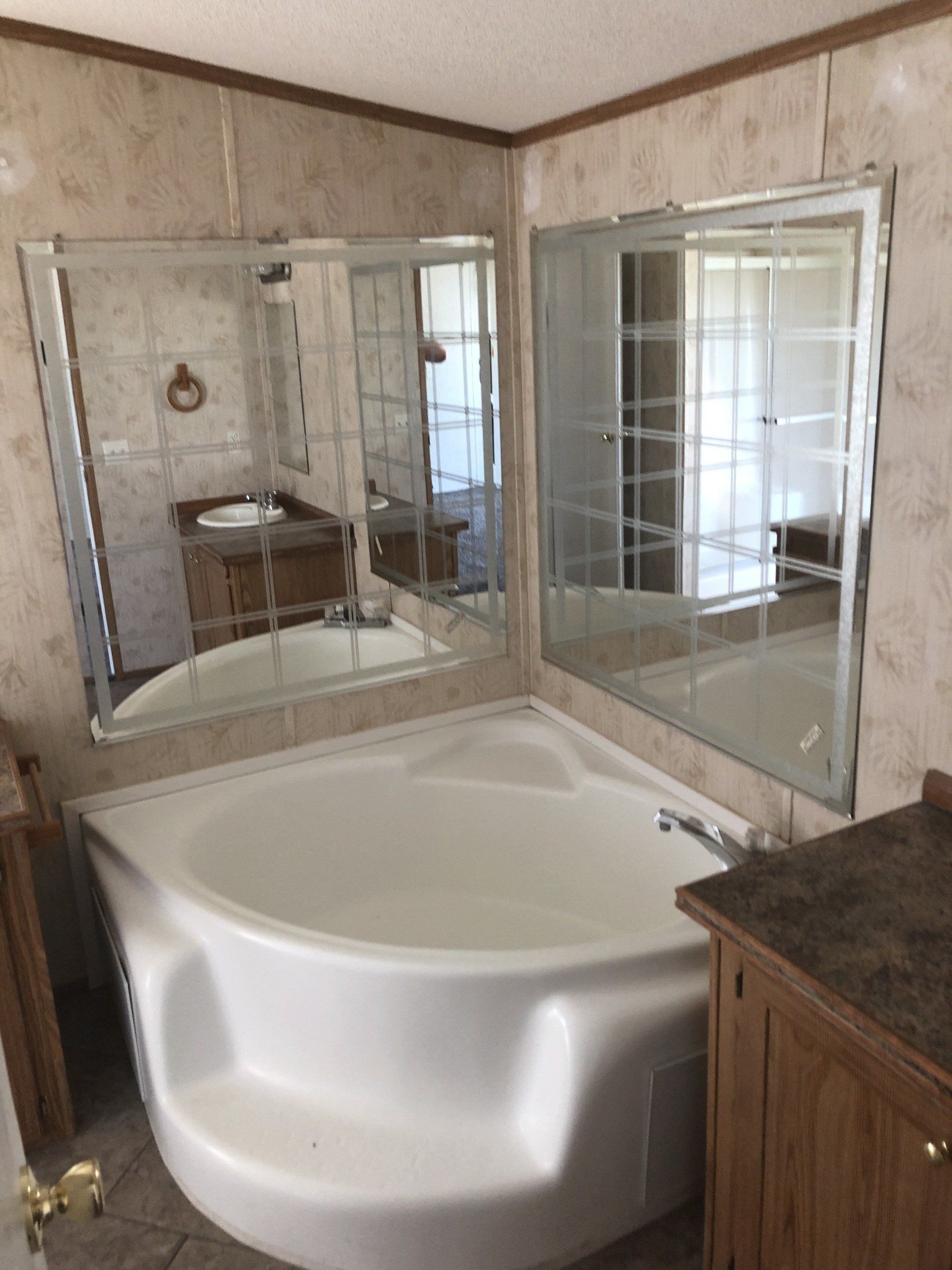 A bathroom with a large tub and a large mirror