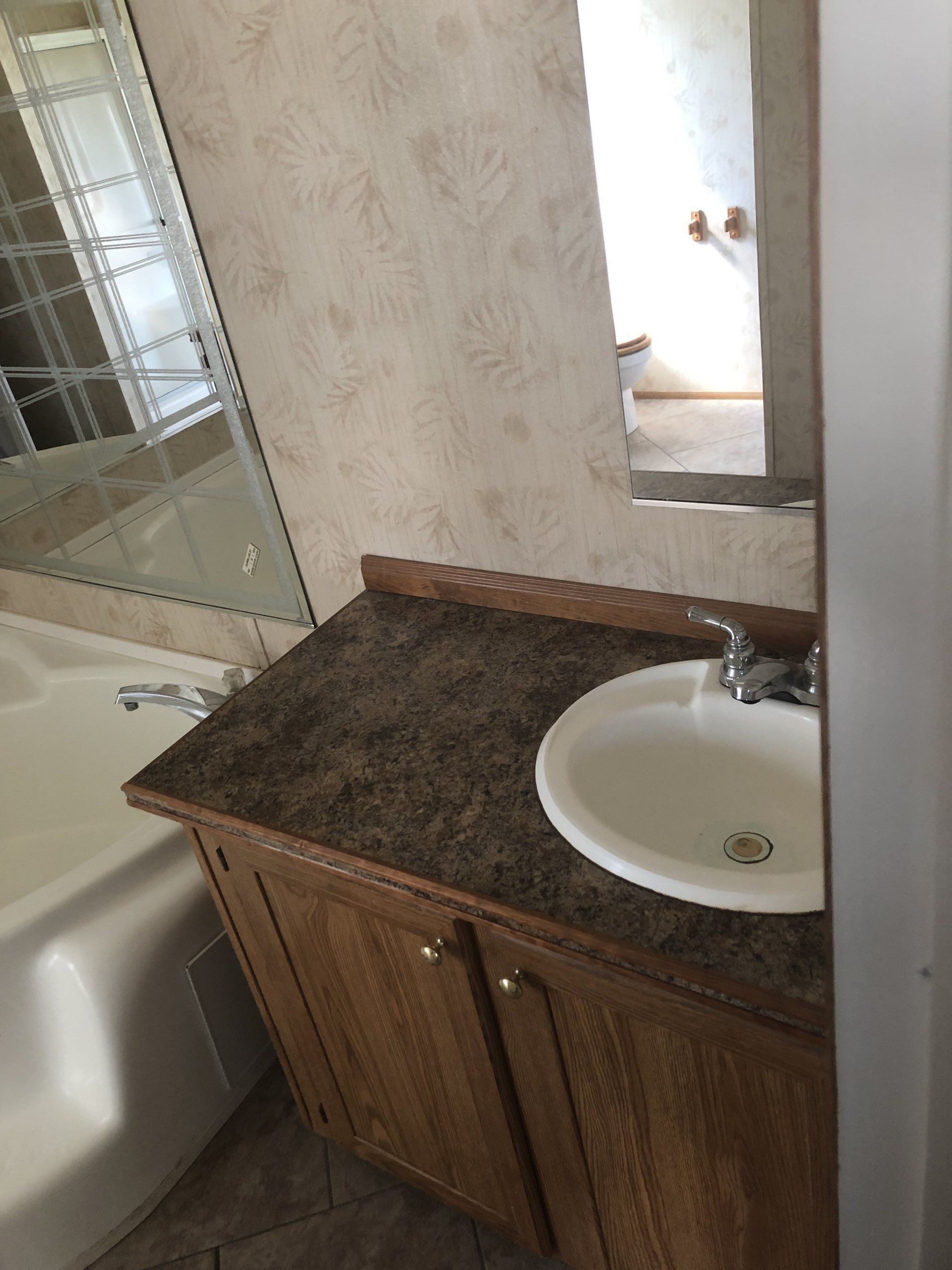 A bathroom with a sink a tub and a mirror