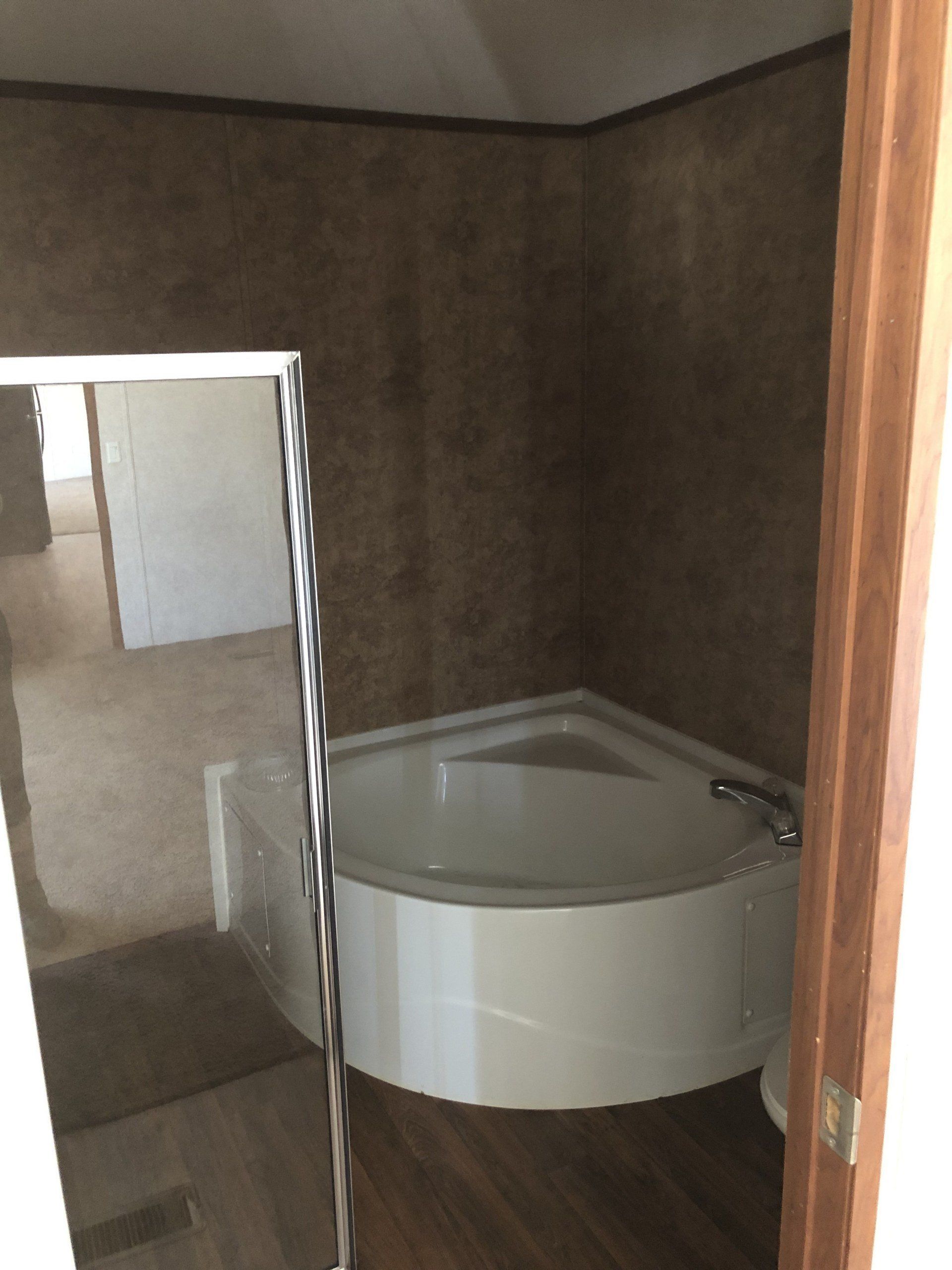 A bathroom with a bathtub and a mirror