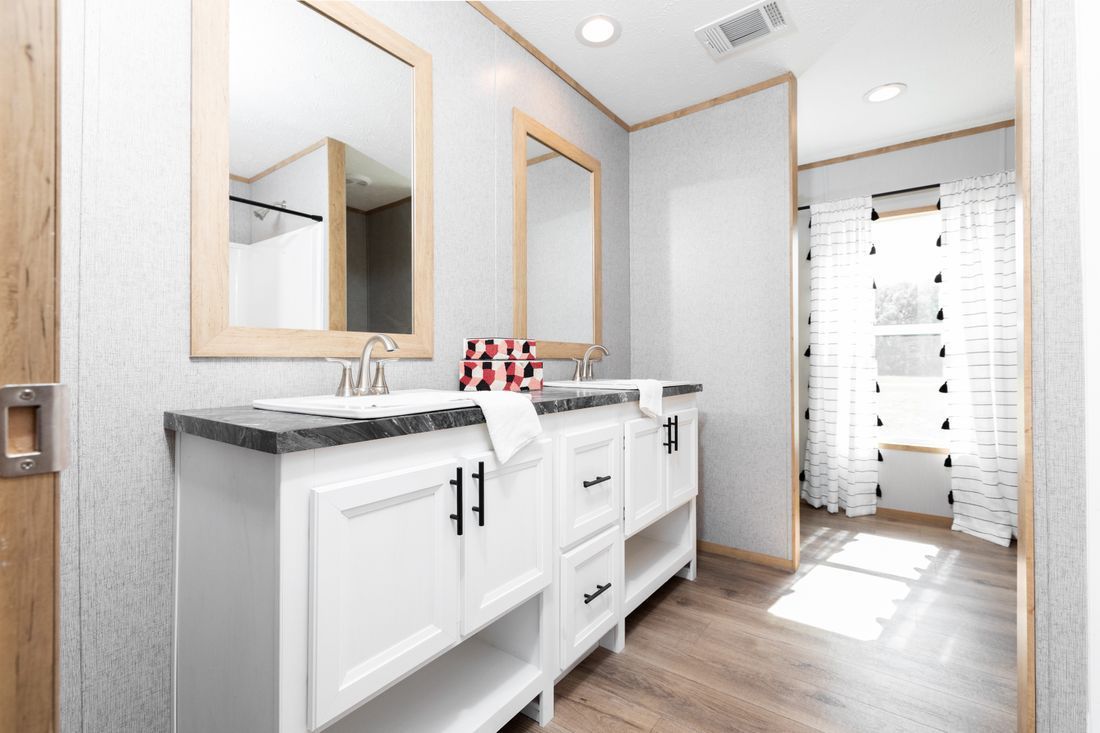 a bathroom with two sinks and two mirrors