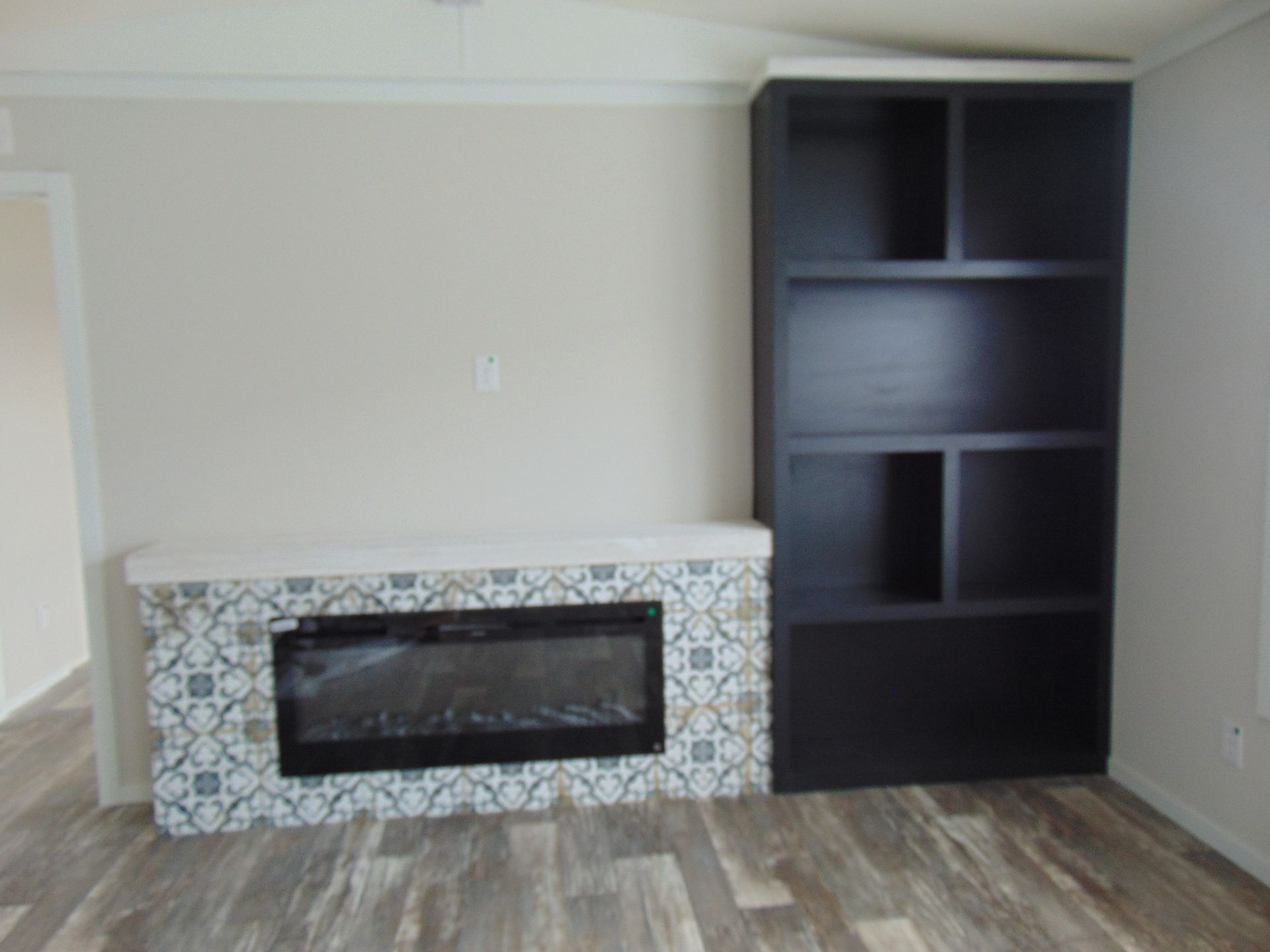 a living room with a fireplace and a bookshelf