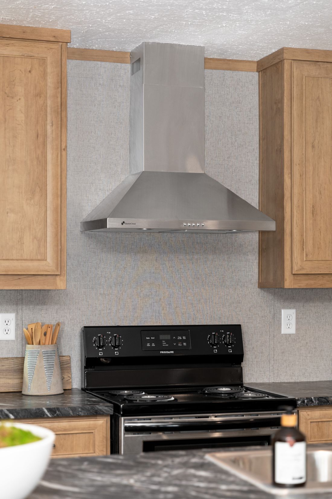 a kitchen with a stove and a hood above it