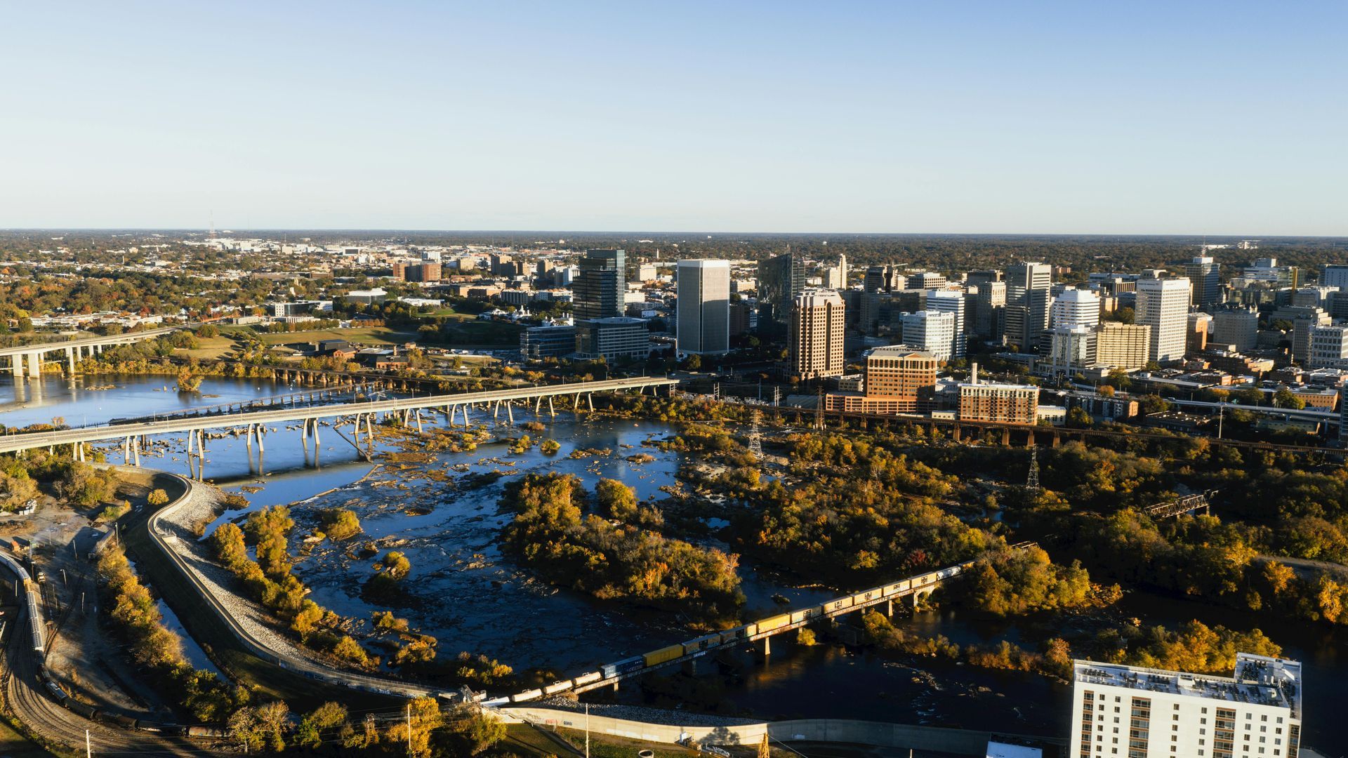 Aerial view of Richmond, Virginia, cityscape with James River and bridges in the foreground.