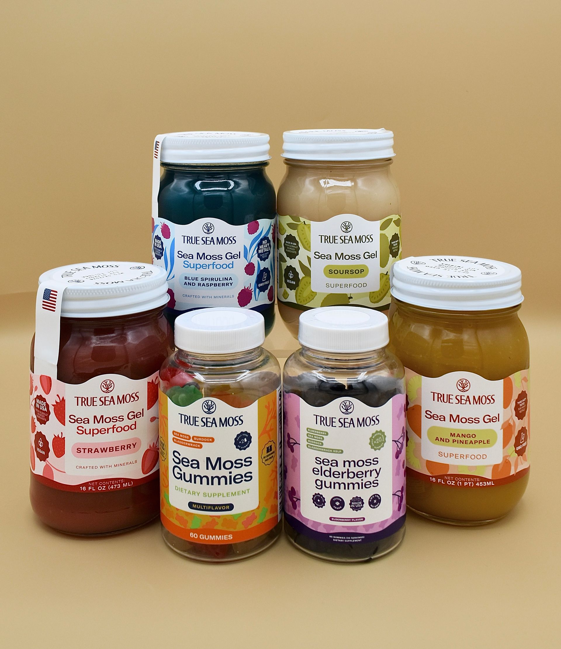 Six jars of colorful jam or preserves arranged on a beige background.