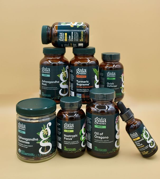 Assorted dark glass jars and bottles with green labels stacked on a beige background