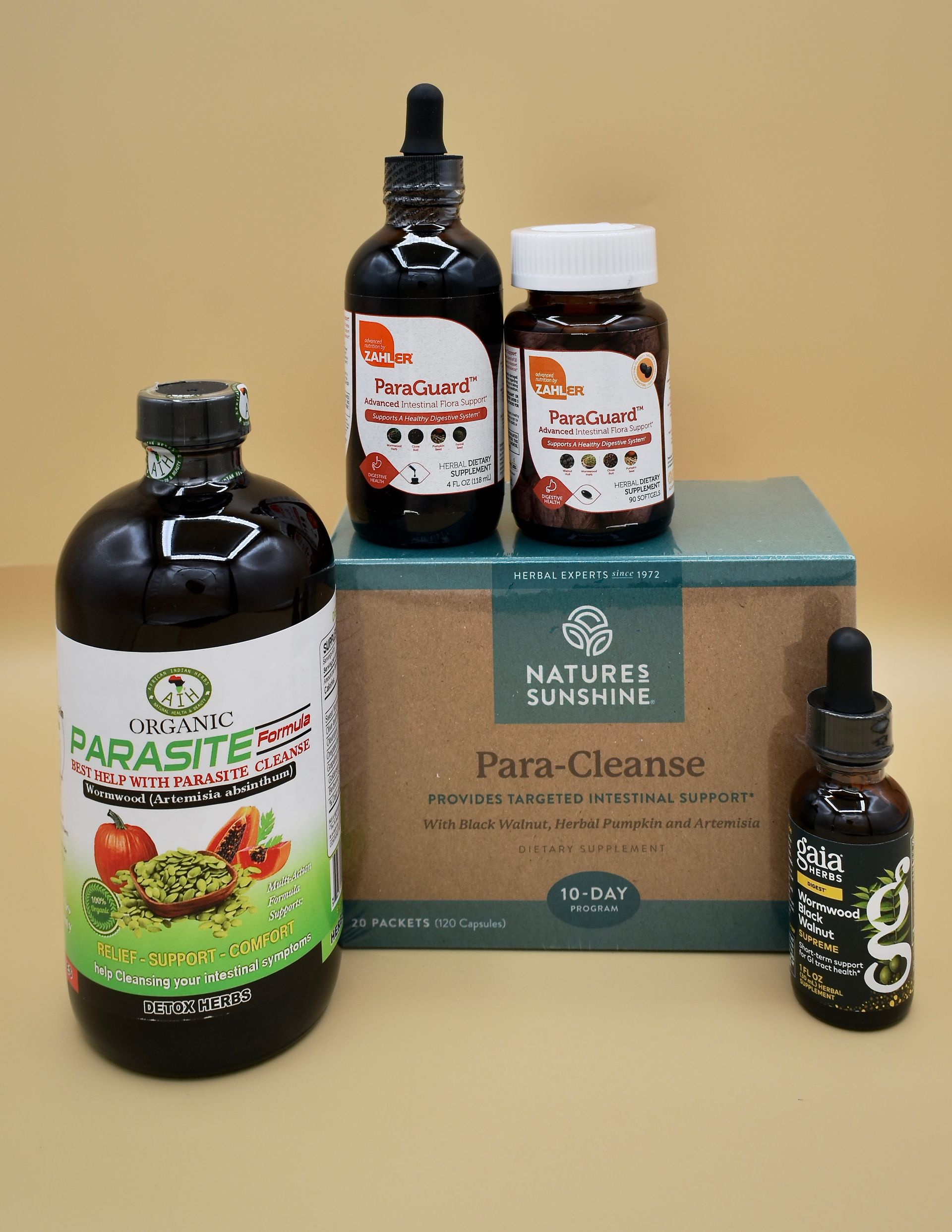 Assorted Nature’s Sunshine supplement bottles and boxes arranged on a beige surface.