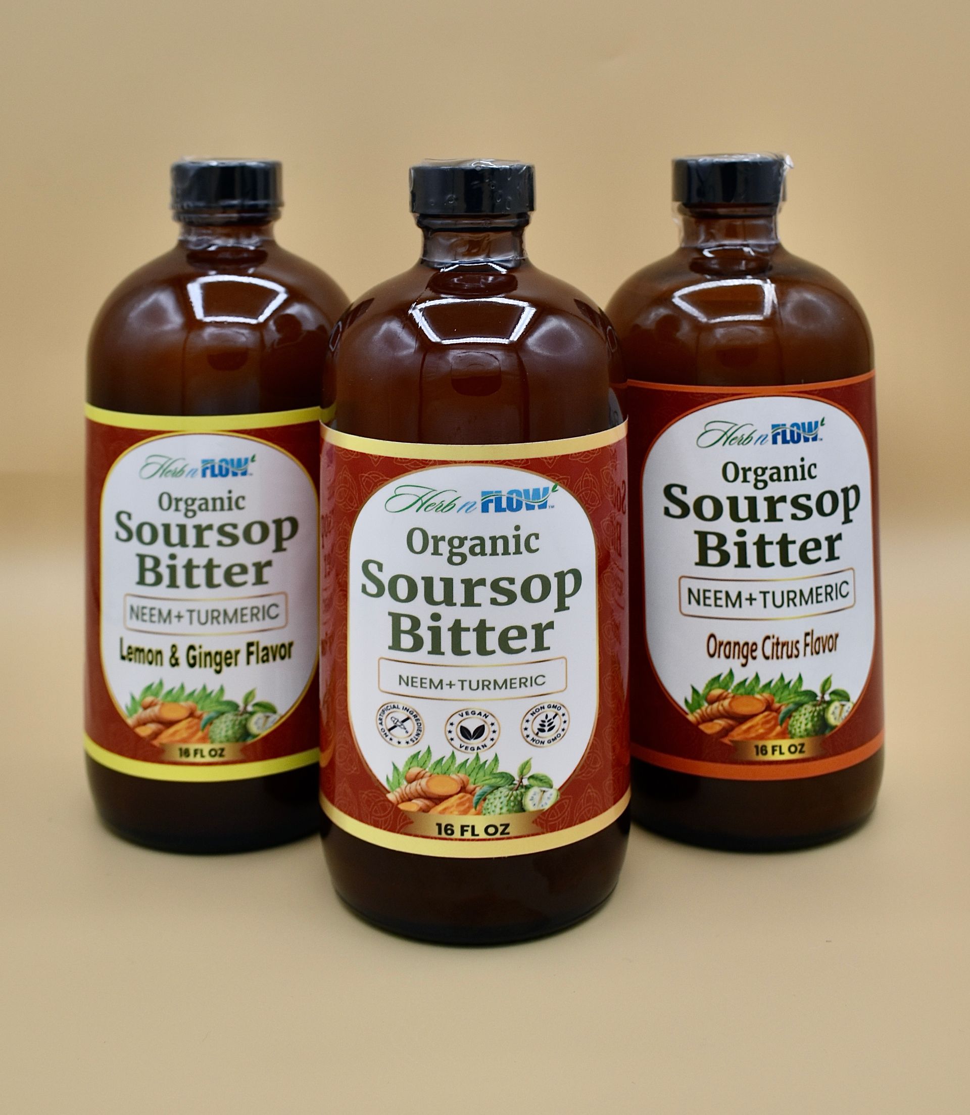 Three brown bottles of organic soursop bitter on a beige background