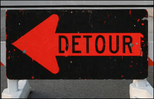 A black and red detour sign