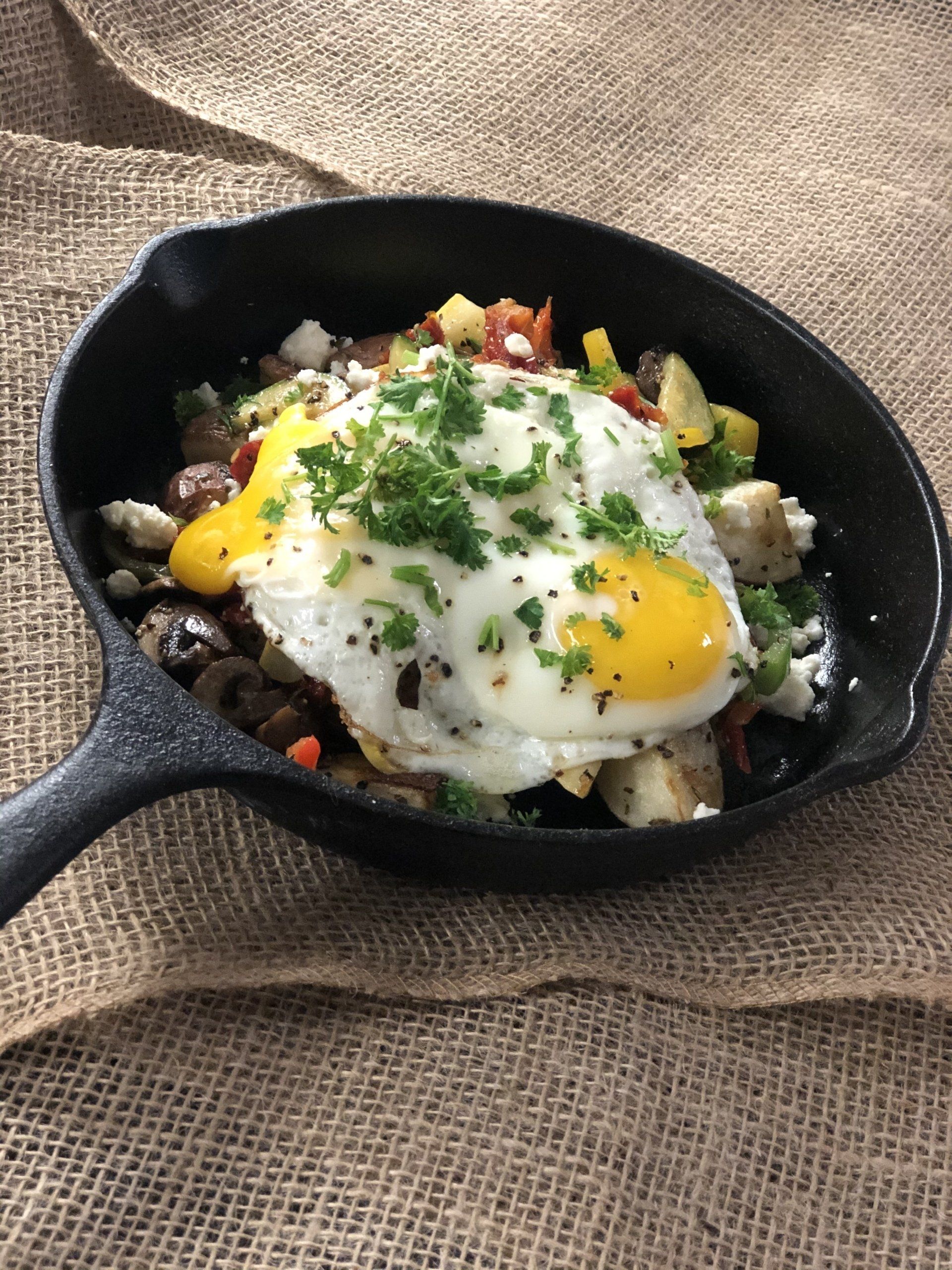 A skillet filled with eggs and vegetables on a table