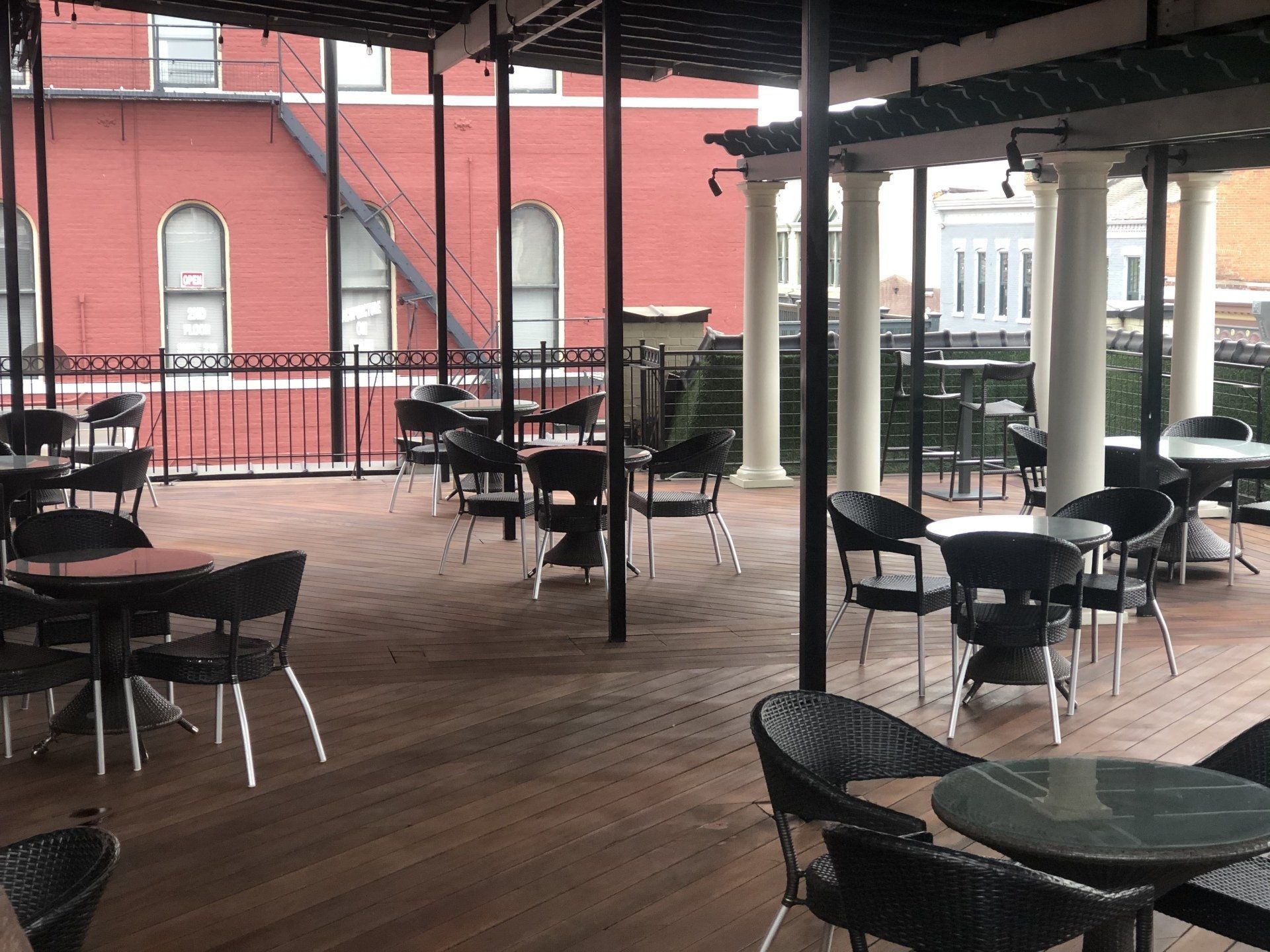 A patio with tables and chairs in front of a red building