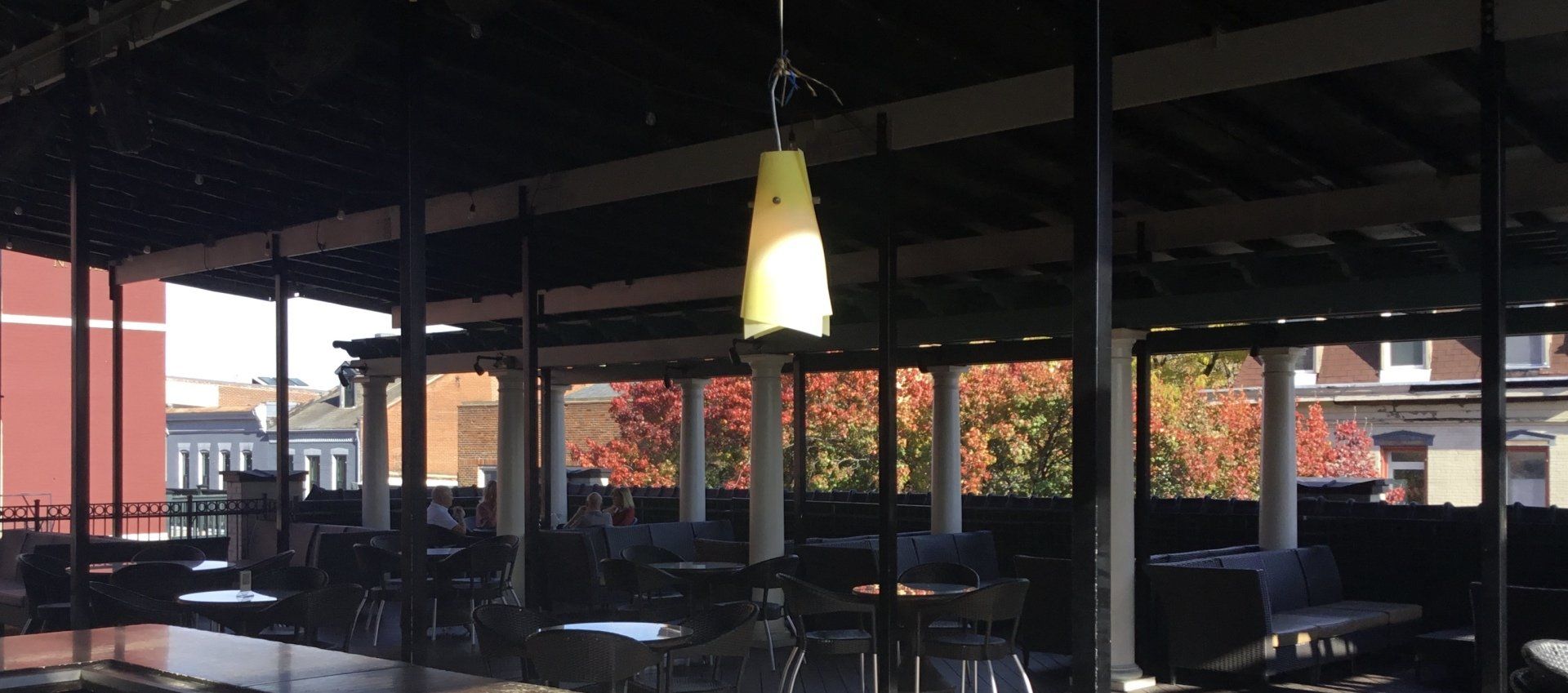 A restaurant with tables and chairs and a light hanging from the ceiling