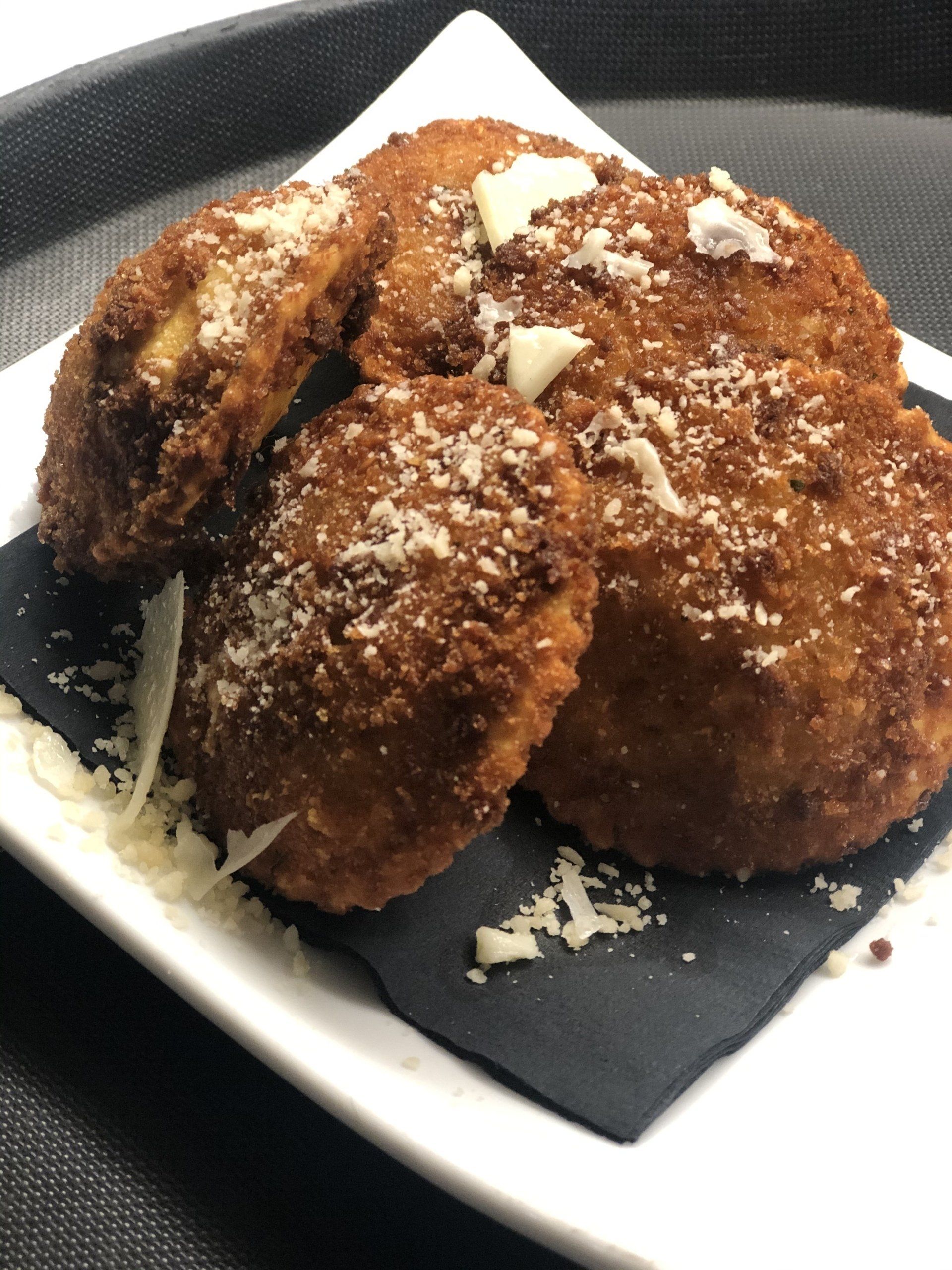 A white plate topped with fried food on a napkin