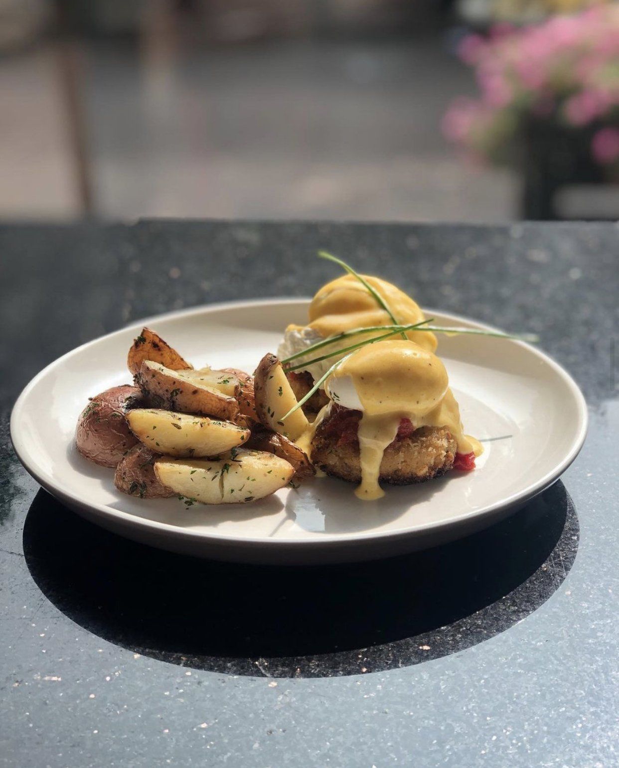 A plate of food with potatoes and eggs on a table.