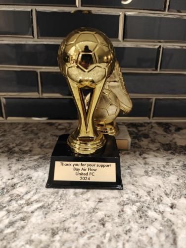 Gold soccer trophy on a black base with a plaque that reads: “Thank you for your support, Boy Air Flow, United FC 2020.”