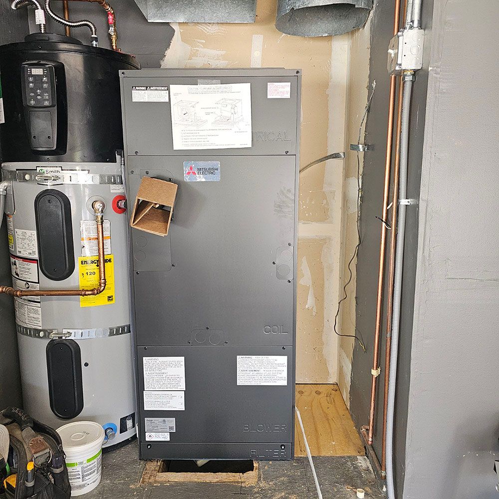 HVAC unit and water heater in a utility room. Gray and beige tones, various pipes and ducts.