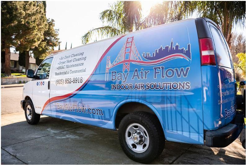 A white and blue service van with thye Business Air Flor information.