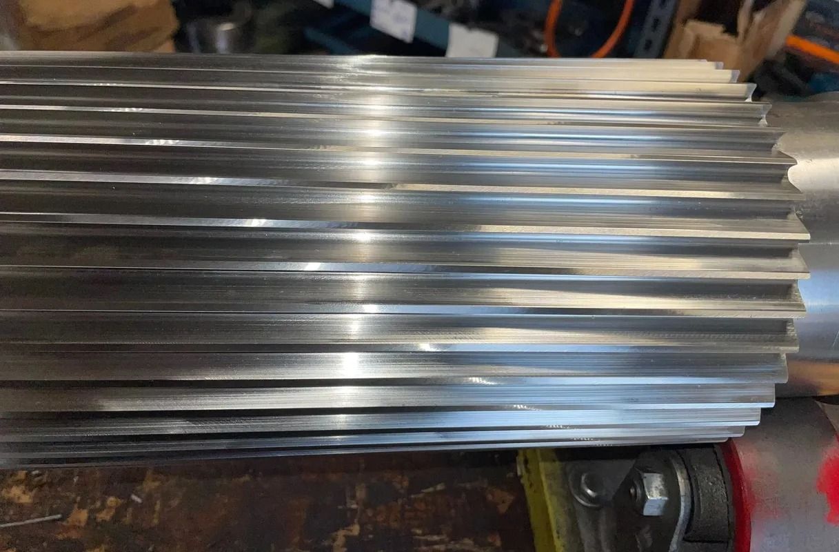 Stack of shiny silver metal sheets on a workbench in a workshop