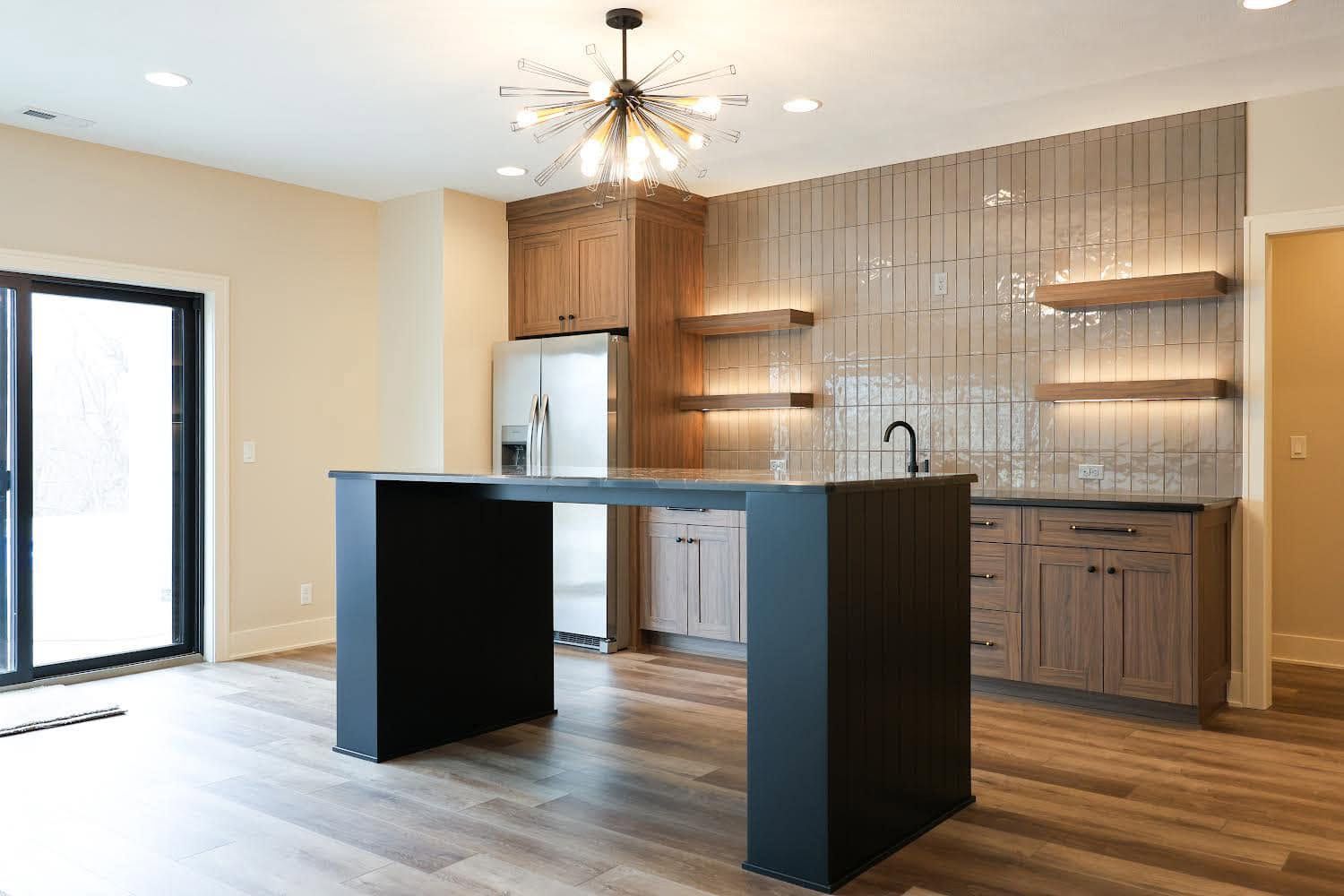 Modern kitchen with island, wood cabinets, tiled backsplash, and sliding glass door