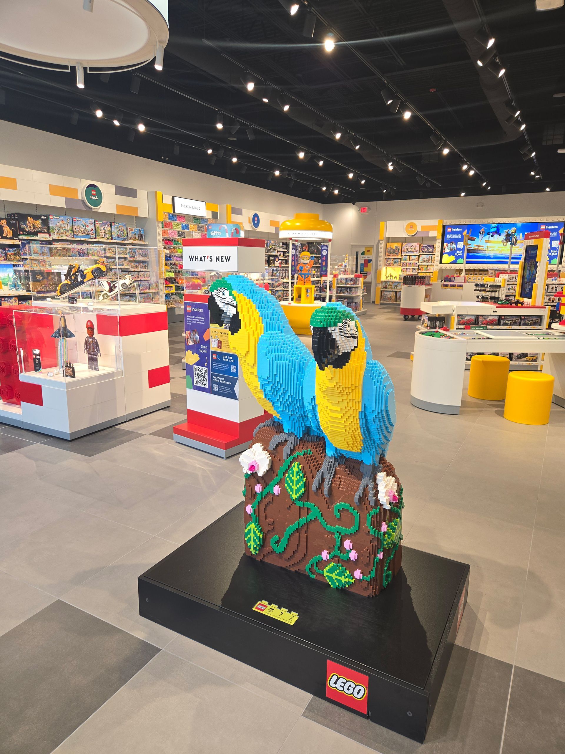 LEGO-style blue-and-yellow parrots display in a bright toy store aisle
