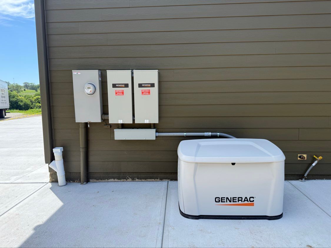 Outdoor backup generator beside utility meters on a brown building wall