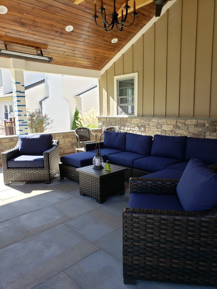 Brick pathway winding through landscaped yard, illuminated by ground lights, beside a white picket fence.