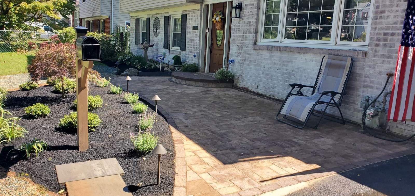 Outdoor stone barbecue with patio and seating area.
